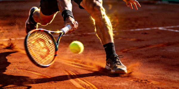 网球运动员在红土场上奋力挥拍击球